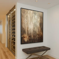 Wine cellar with glass door, abstract painting on wall, and brown bench.